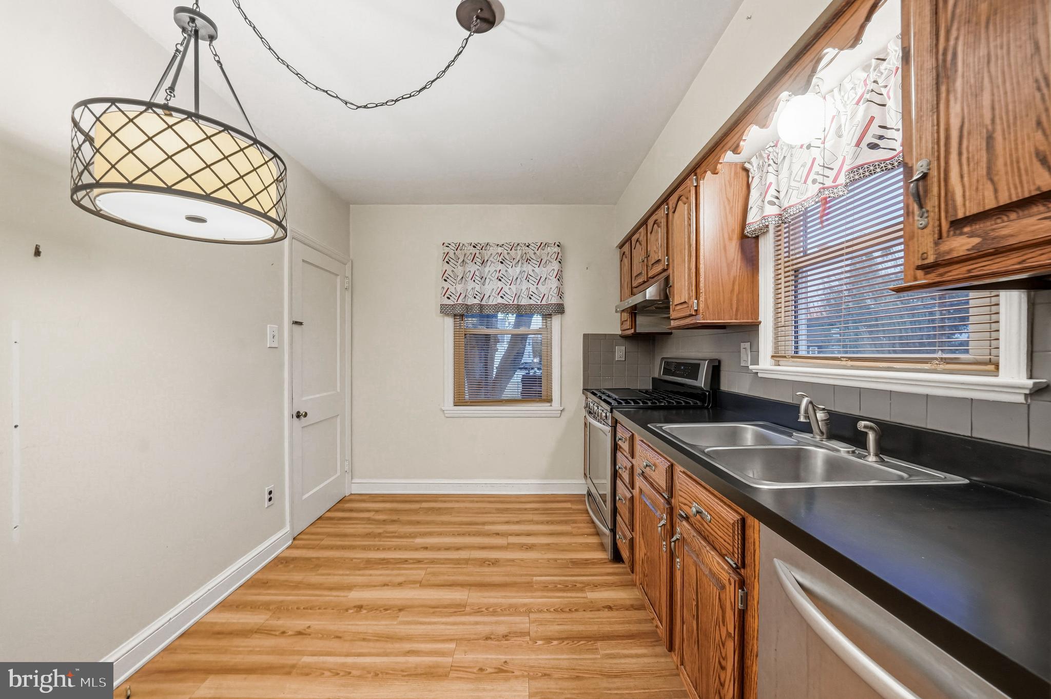 101 6th Avenue Mount Ephraim, NJ 08059 - Photo 11 of 27 a kitchen with stainless steel appliances granite countertop a sink a stove and a wooden floors