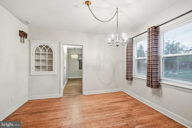 a view of a livingroom with wooden floor and windows