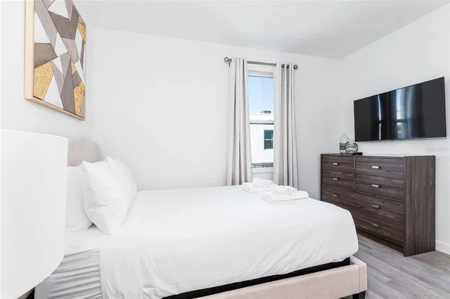 a bedroom with a bed and a flat screen tv