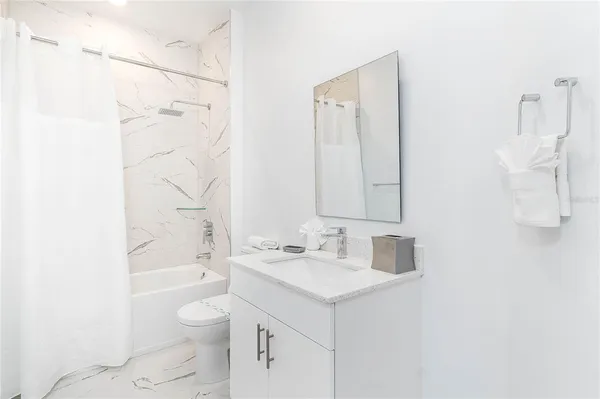 a bathroom with a sink toilet vanity and shower
