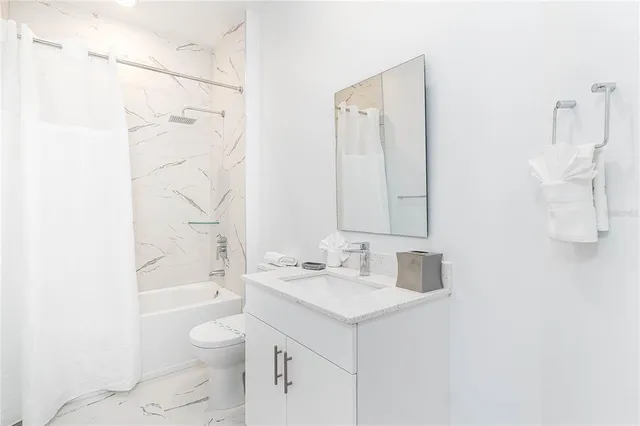 a bathroom with a sink toilet vanity and shower