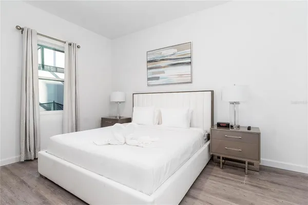 a bedroom with a bed and wooden floor