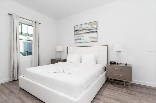 a bedroom with a bed and wooden floor