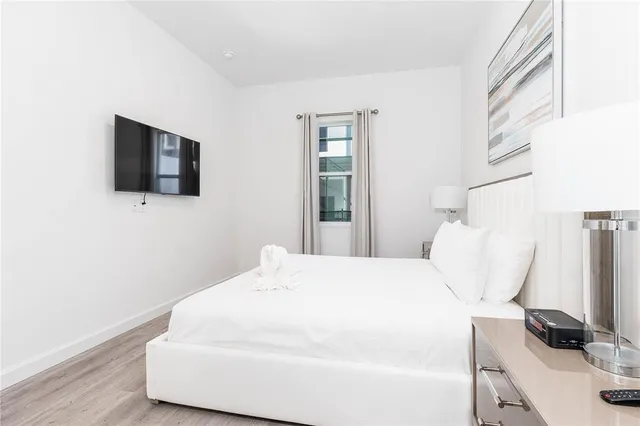 a bedroom with a bed and a flat screen tv