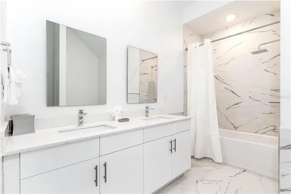 a bathroom with a double vanity sink mirror double and bathtub
