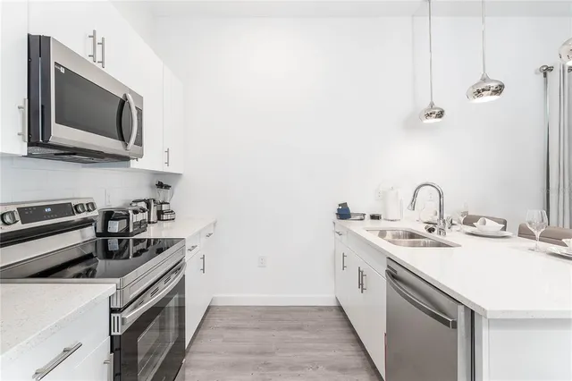 a kitchen with a sink and stainless steel appliances