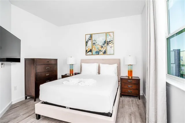 a bedroom with a bed and a flat screen tv