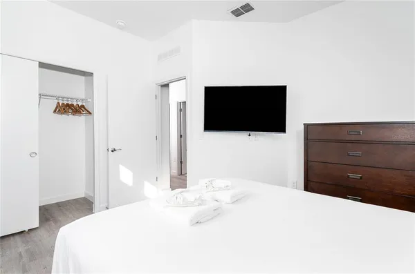 a bedroom with a bed and a flat screen tv