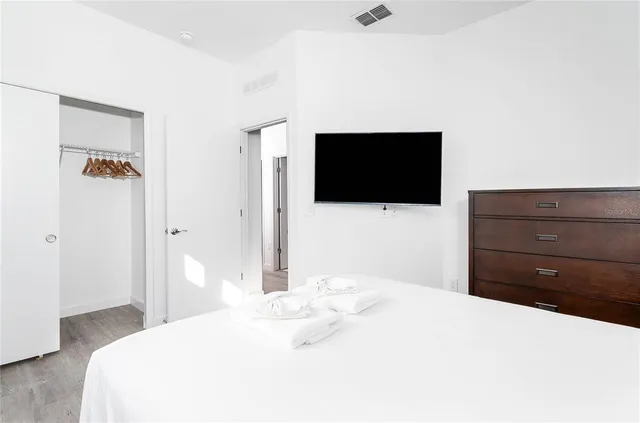 a bedroom with a bed and a flat screen tv