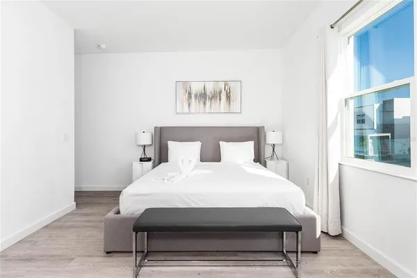 a large bed sitting in a bedroom next to a window