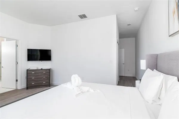 a bedroom with a bed and a flat screen tv