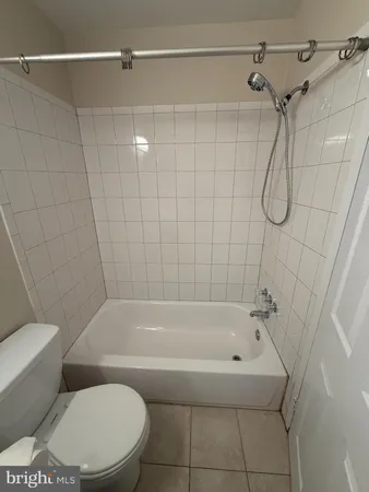 a white bath tub sitting next to a white toilet and a shower