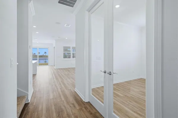 a view of a hallway with wooden floor and staircase