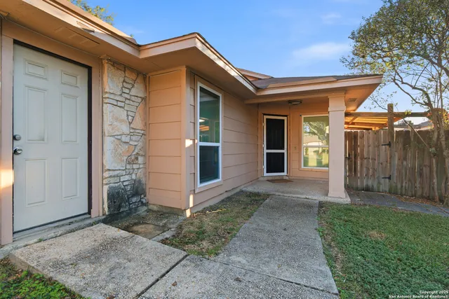 a view of a house with a small yard and wooden fence