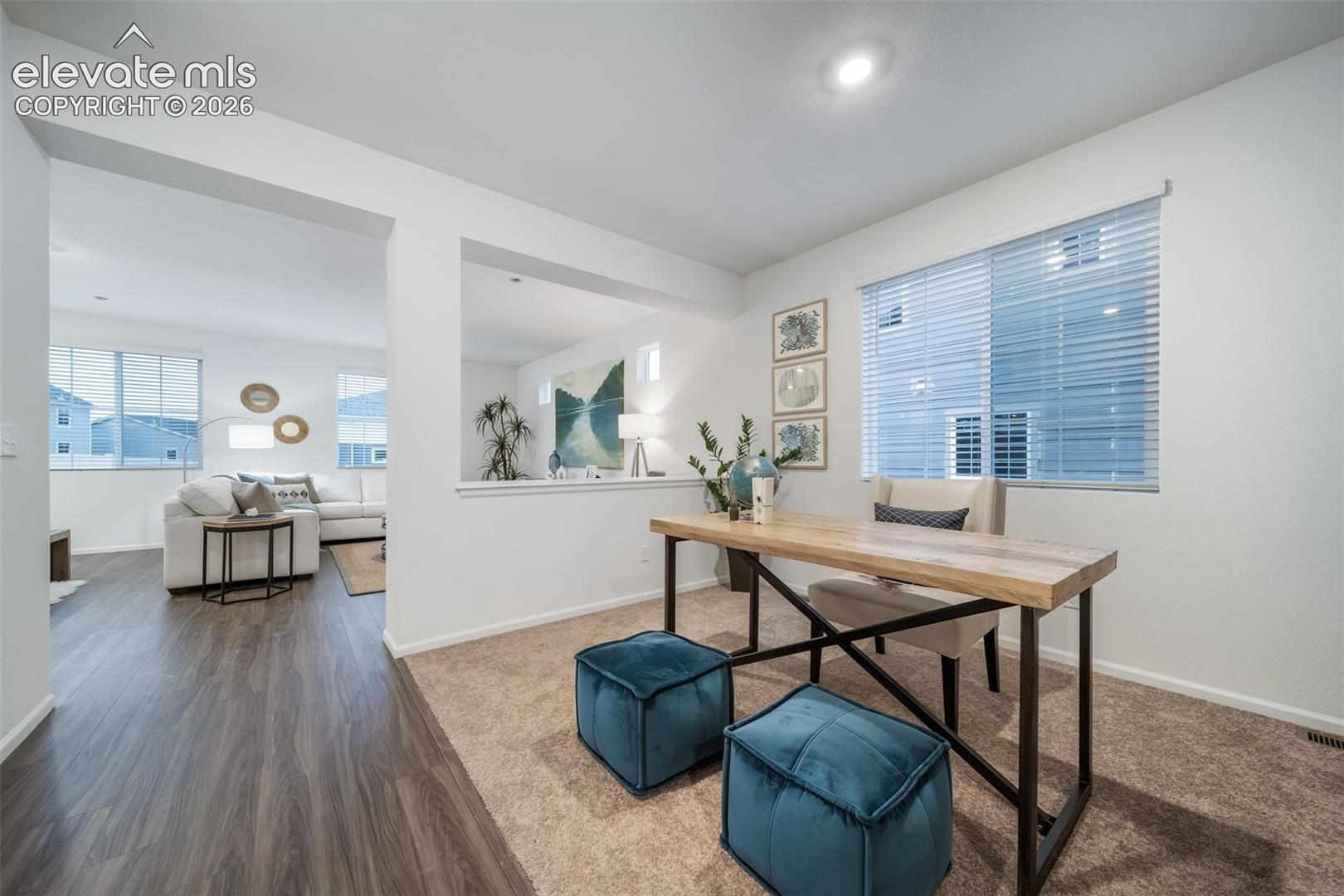 4936 Truscott Road Colorado Springs, CO 80925 - Photo 14 of 41 Recessed lighting, wood-finish flooring, white walls, and a large window with blinds
*photos of a model home*