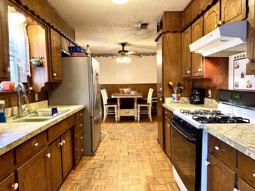 317 North Trail Street Crowley, TX 76036 - Photo 8 of 35 a kitchen with stainless steel appliances granite countertop a stove a sink and a refrigerator