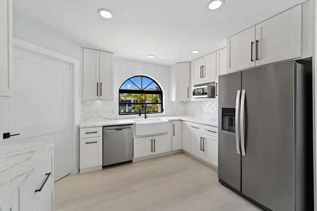 a spacious bedroom with a large bed and a chandelier
