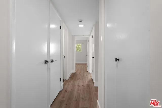 a view of a hallway with wooden floor