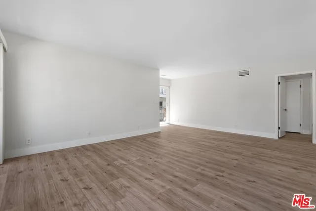 a view of an empty room and wooden floor