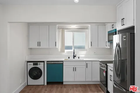 a kitchen with stainless steel appliances white cabinets and a sink