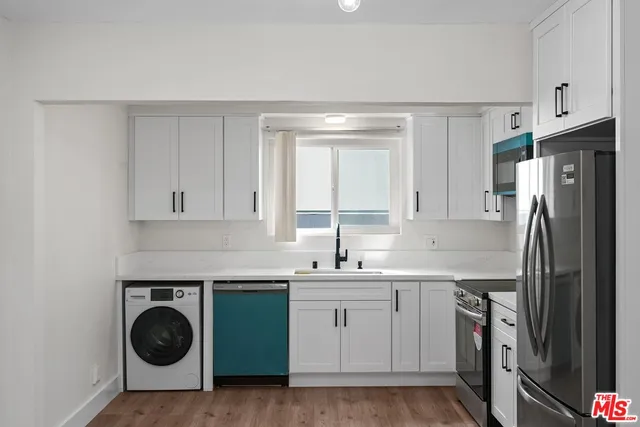 a kitchen with stainless steel appliances white cabinets and a sink