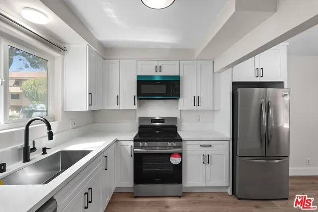 a kitchen with a refrigerator sink and cabinets