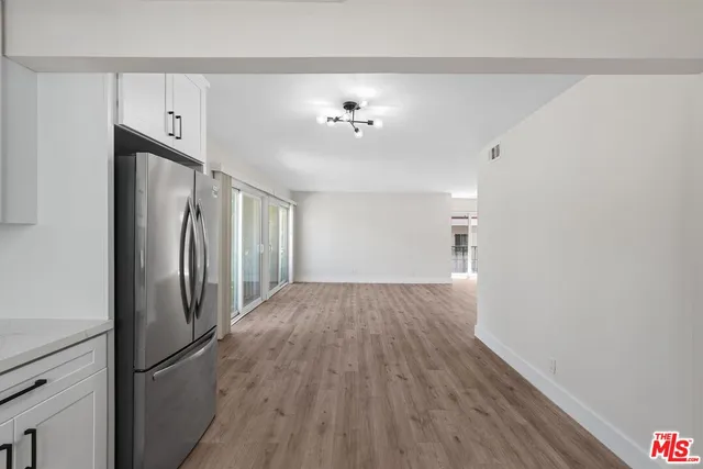 a view of a refrigerator in kitchen and wooden floor