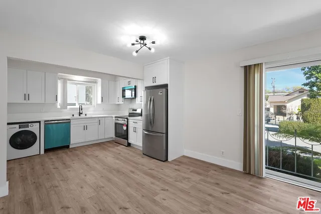 a kitchen that has a lot of cabinets a sink and appliances in it