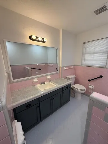 a bathroom with a double vanity sink toilet and mirror