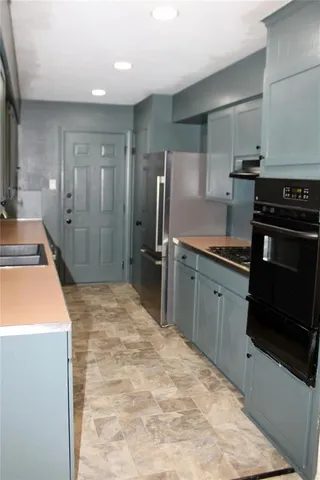 a kitchen with stainless steel appliances granite countertop a sink and a stove top oven