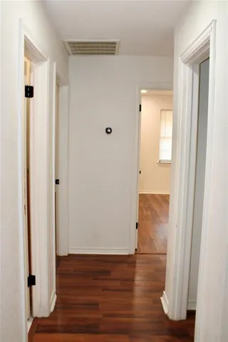 a view of a hallway with wooden floor