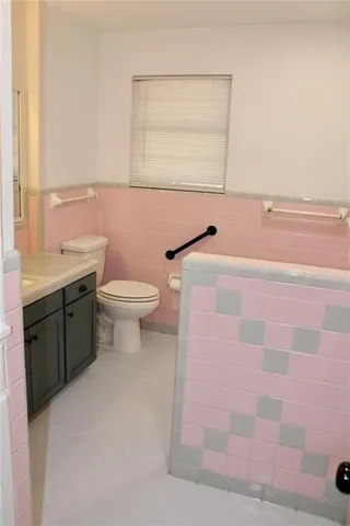 a bathroom with a sink a toilet and a mirror