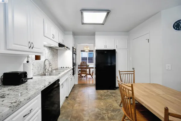 a kitchen with granite countertop cabinets a sink a window and stainless steel appliances