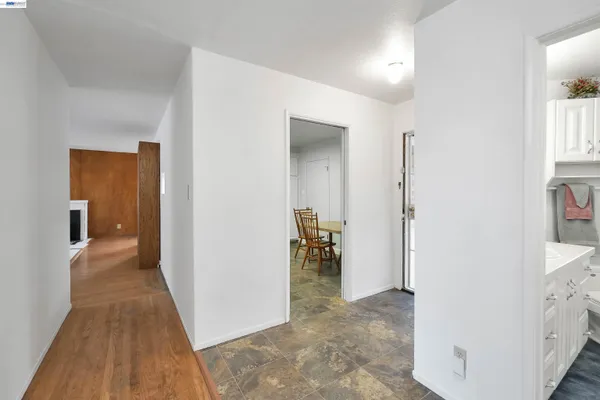 a view of a hallway with bathroom and wooden floor