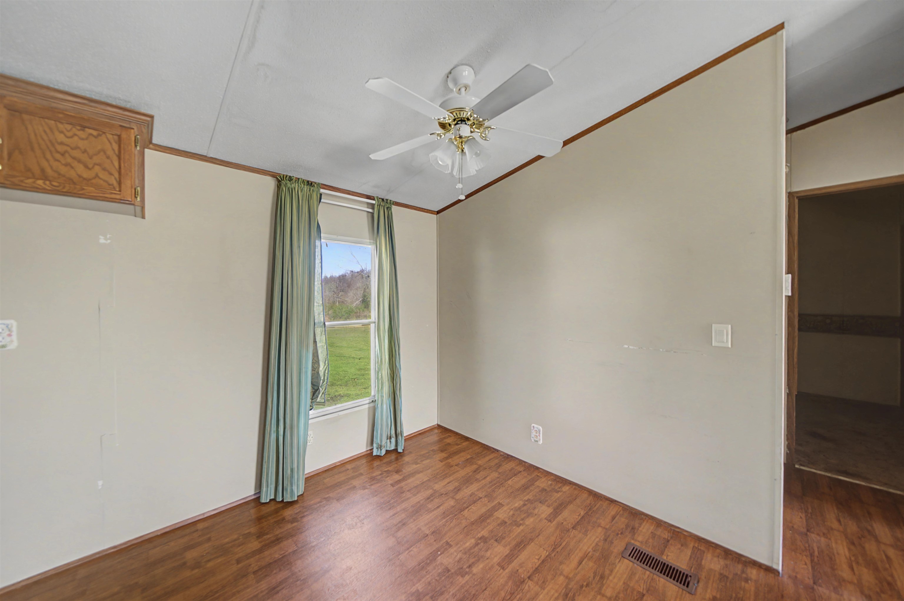 1788 Nichols Road Guys, TN 38339 - Photo 12 of 21 Unfurnished room featuring dark wood-style flooring, ceiling fan, and ornamental molding