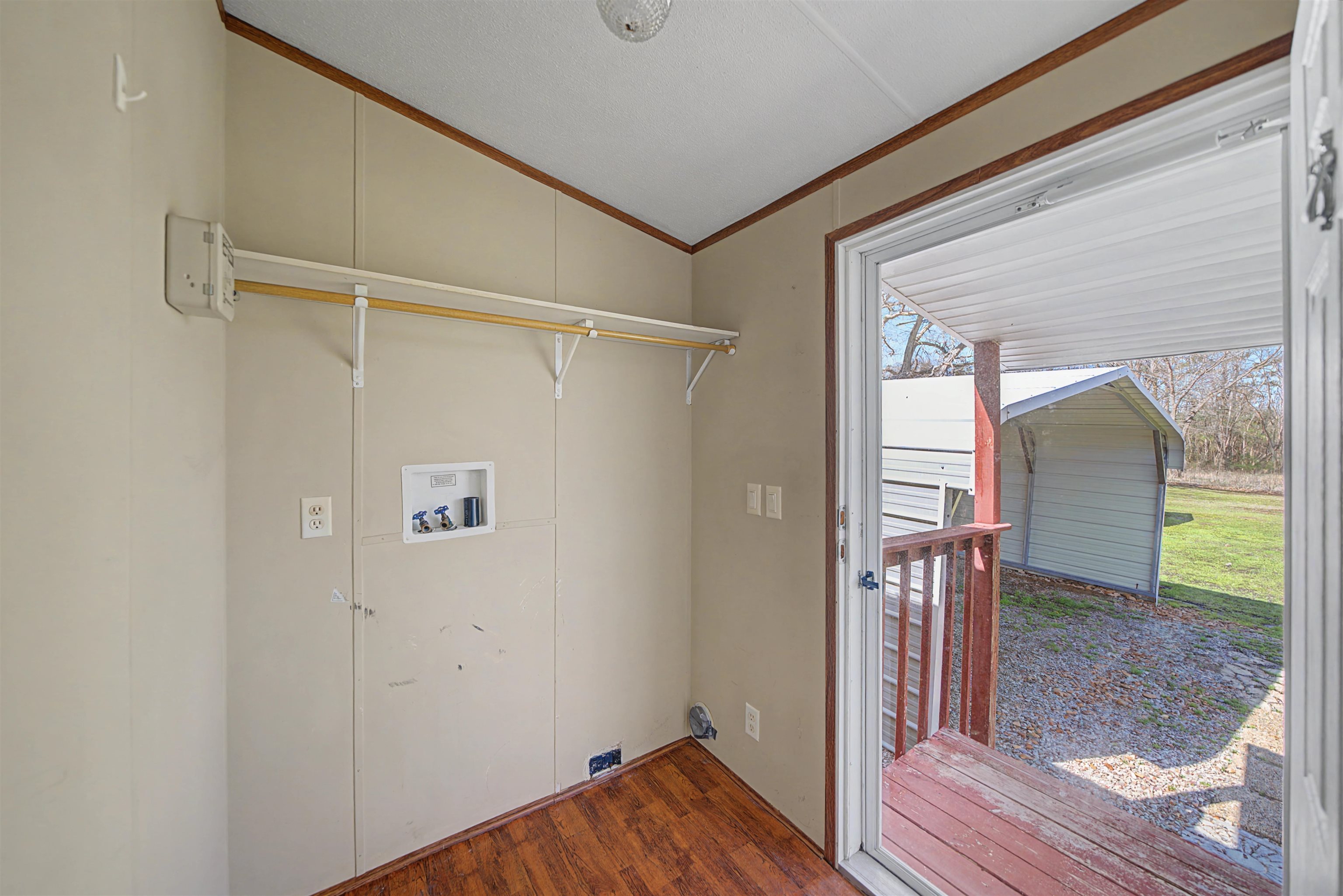 1788 Nichols Road Guys, TN 38339 - Photo 14 of 21 Laundry area with dark wood finished floors, vaulted ceiling, crown molding, and hookup for a washing machine