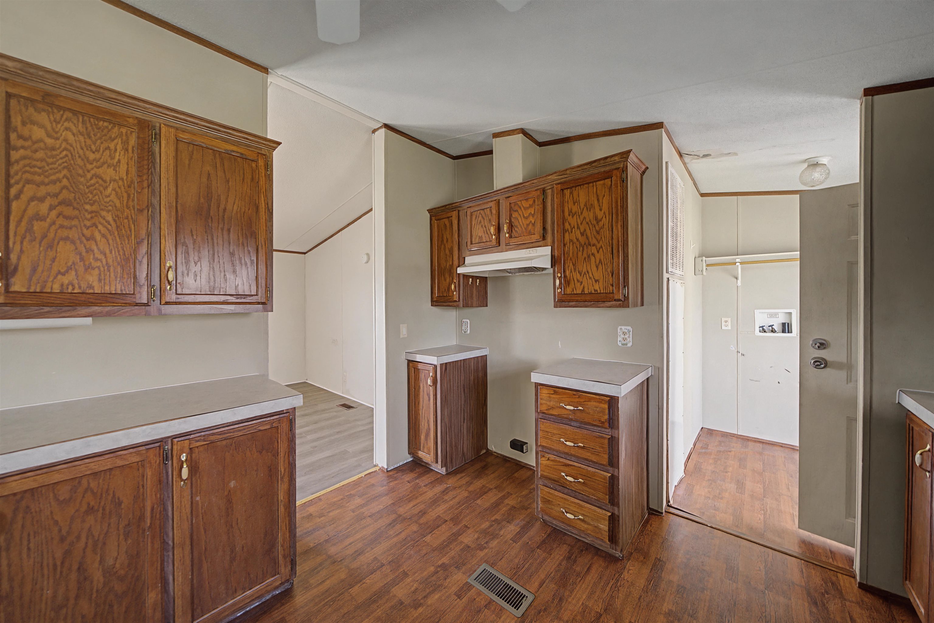 1788 Nichols Road Guys, TN 38339 - Photo 19 of 21 Kitchen featuring wood finish cabinetry, light countertops, dark wood finished floors, and ornamental molding