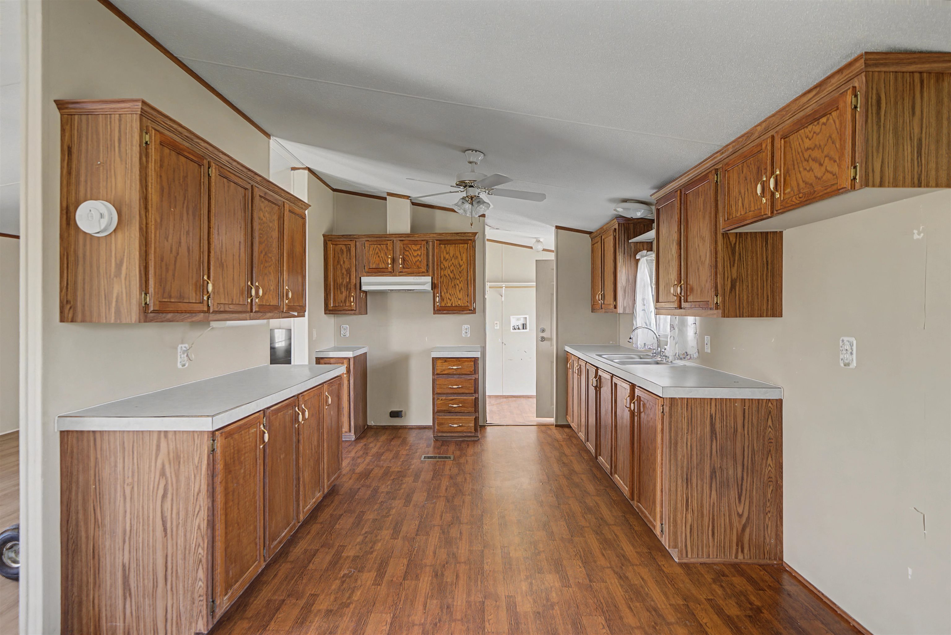 1788 Nichols Road Guys, TN 38339 - Photo 21 of 21 Kitchen featuring wood finish cabinetry, dark wood-type flooring, light countertops, lofted ceiling, and a ceiling fan