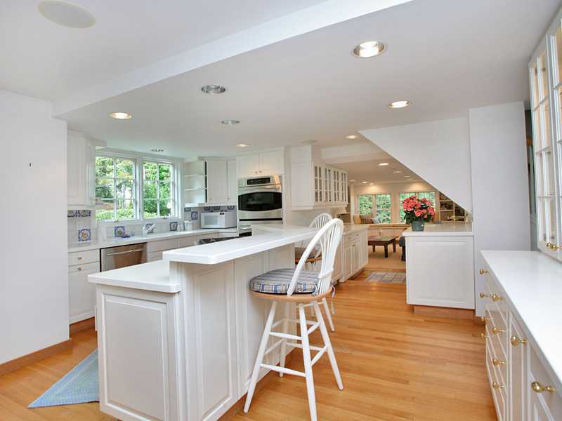 480 Hollow Tree Ridge Road Darien, CT 06820 - Photo 8 of 25 a kitchen with stainless steel appliances kitchen island wooden floors and white cabinets