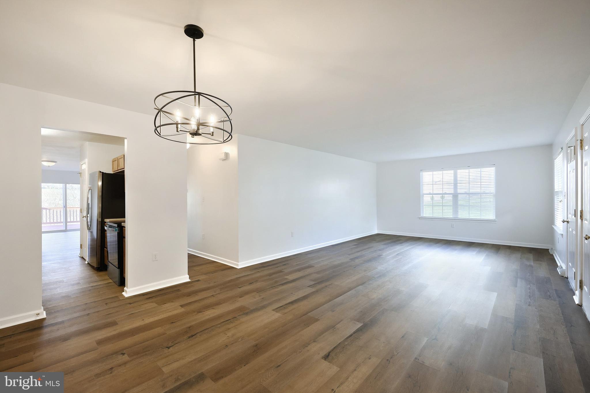 7220 Seneca Ridge Drive York, PA 17403 - Photo 12 of 51 a view of empty room with wooden floor and kitchen