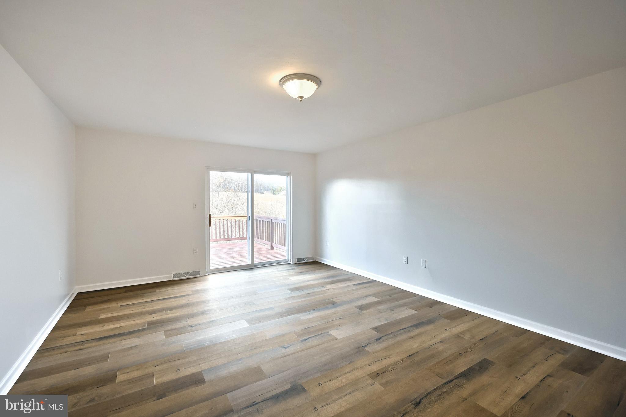 7220 Seneca Ridge Drive York, PA 17403 - Photo 19 of 51 a view of an empty room with wooden floor and a window