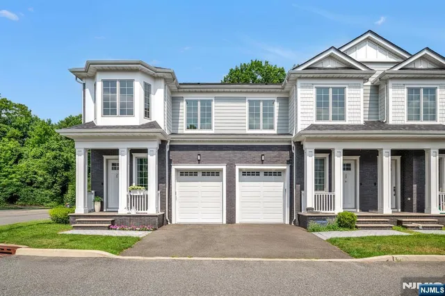 a front view of a house with a yard and trees