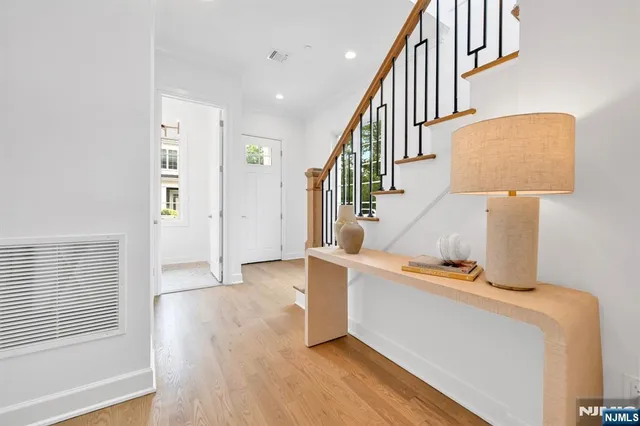 a view of hallway with stairs and wooden floor