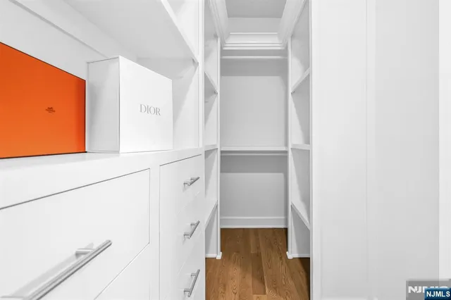 a view of walk in closet with wooden floor