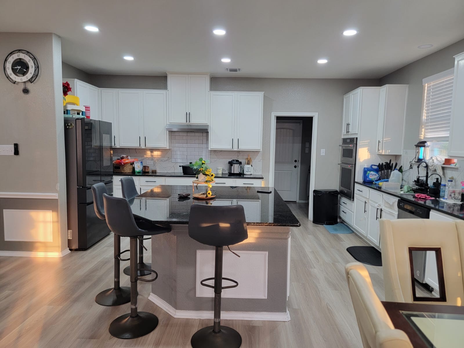 429 Unforgiven Lane Jarrell, TX 76537 - Photo 3 of 10 Spacious kitchen featuring an expansive center island with seating, dark stone countertops, white cabinetry with brushed nickel hardware, and built-in stainless steel appliances
