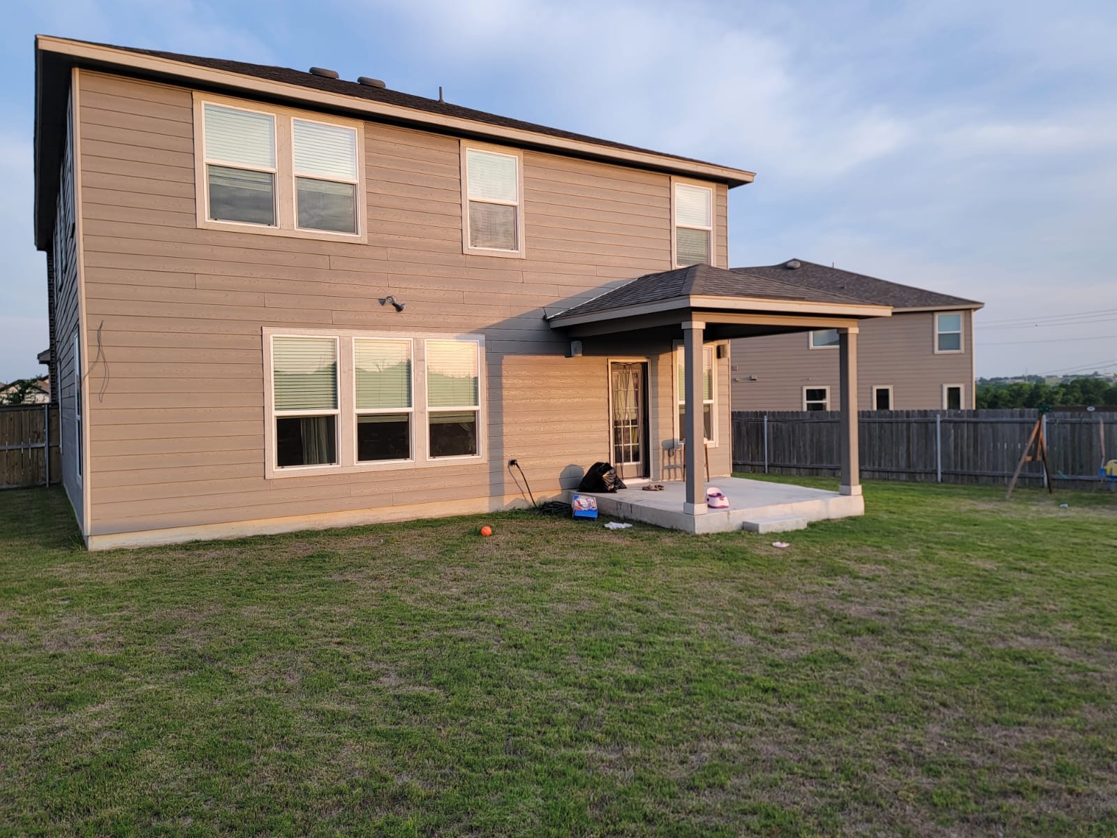429 Unforgiven Lane Jarrell, TX 76537 - Photo 9 of 10 Spacious backyard featuring a covered patio with concrete flooring, siding exterior, and multiple windows across two levels