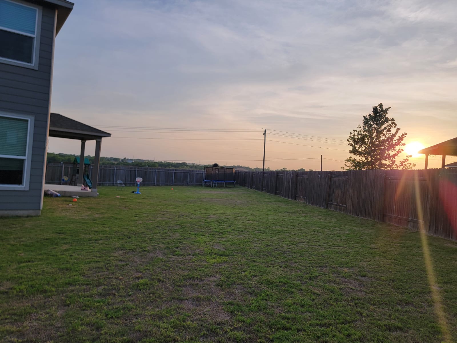 429 Unforgiven Lane Jarrell, TX 76537 - Photo 10 of 10 Expansive backyard featuring a large grass lawn, a wood privacy fence, and a covered concrete patio