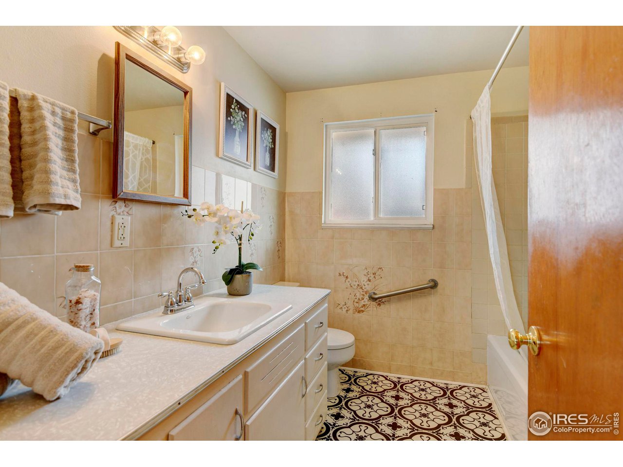 413 Riddle Drive Fort Collins, CO 80521 - Photo 17 of 33 Main level bathroom with new flooring and a nice bathtub with tile surround