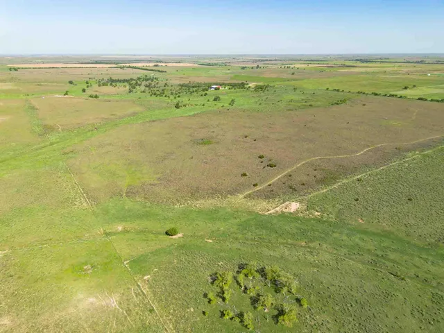 an empty room with a fan & a window
