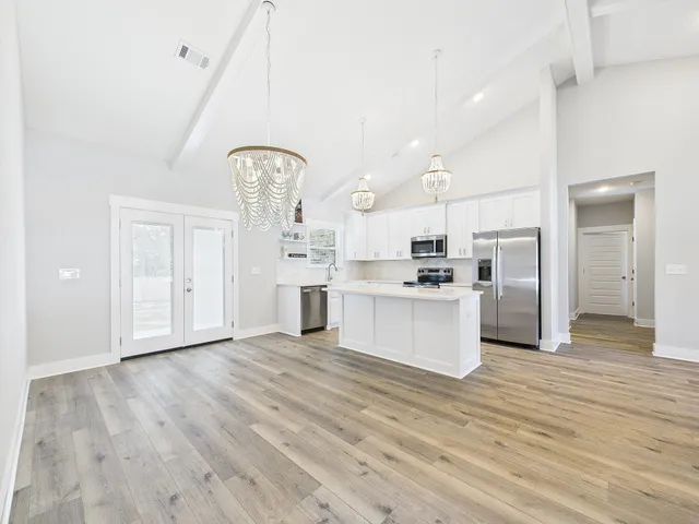 a view of kitchen with granite countertop cabinets and refrigerator